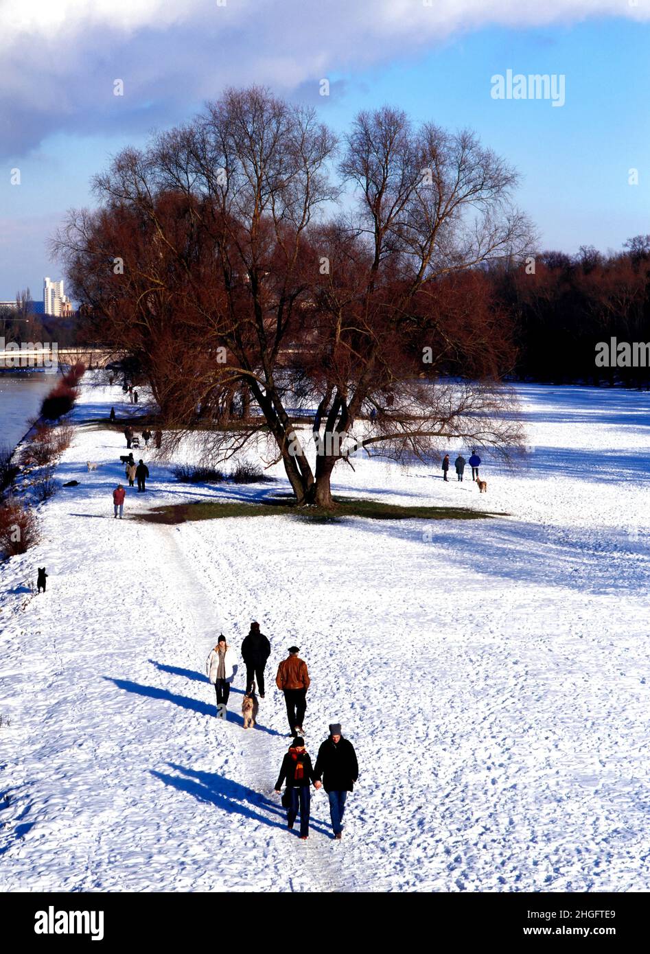 Personnes marchant sur la neige le long de la rivière Isar, Munich, Allemagne Banque D'Images