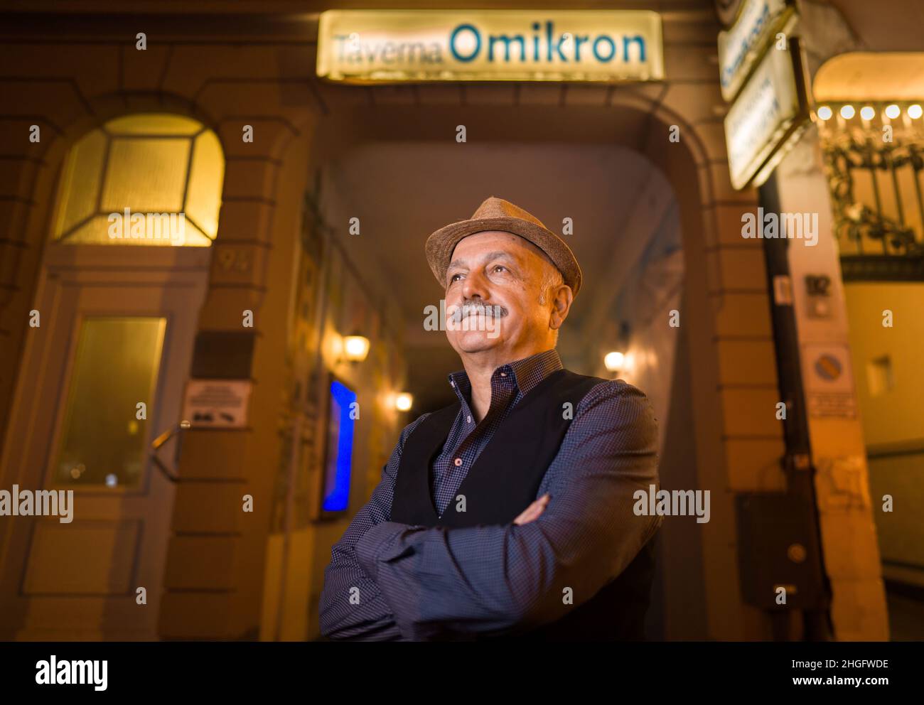 PRODUCTION - 14 janvier 2022, Hessen, Francfort-sur-le-main: Kostas (Konstantinos) Tsapakidis se tient dans la soirée à la porte de son restaurant grec appelé 'Taverna Omikron' dans une arrière-cour du quartier de Bockenheim, qu'il court depuis environ 30 ans.(À dpa 'Taverna 'Omikron', Ice café 'Corona' - les noms des entreprises et la pandémie') photo: Frank Rumpenhorst/dpa/Frank Rumpenhorst/dpa Banque D'Images