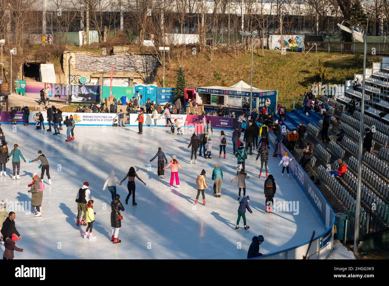 Les gens s'amusent à la patinoire extérieure du stade Yunak, le jour d'hiver ensoleillé à Sofia, en Bulgarie Banque D'Images