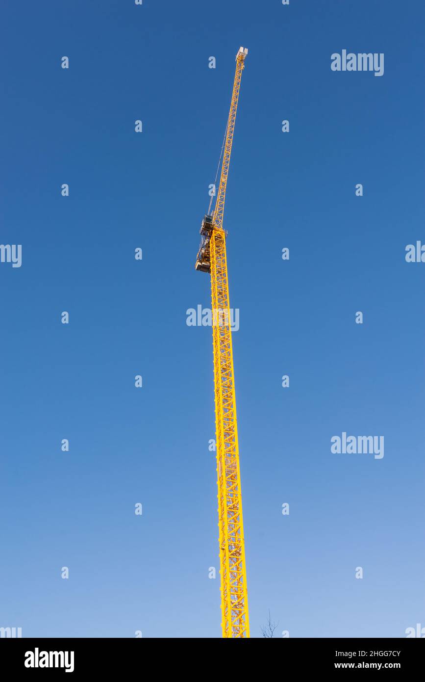 Grande grue de construction jaune contre ciel bleu clair Banque D'Images
