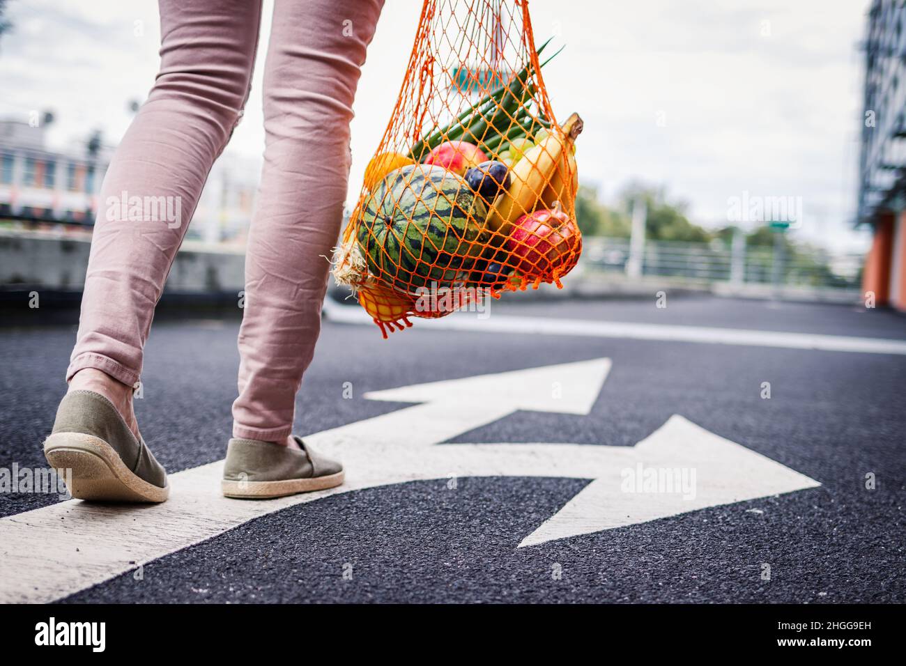 Choisissez la bonne direction pour un mode de vie sain et durable sans gaspillage.Achats gratuits en plastique.Femme avec sac en maille réutilisable rempli de fruits Banque D'Images