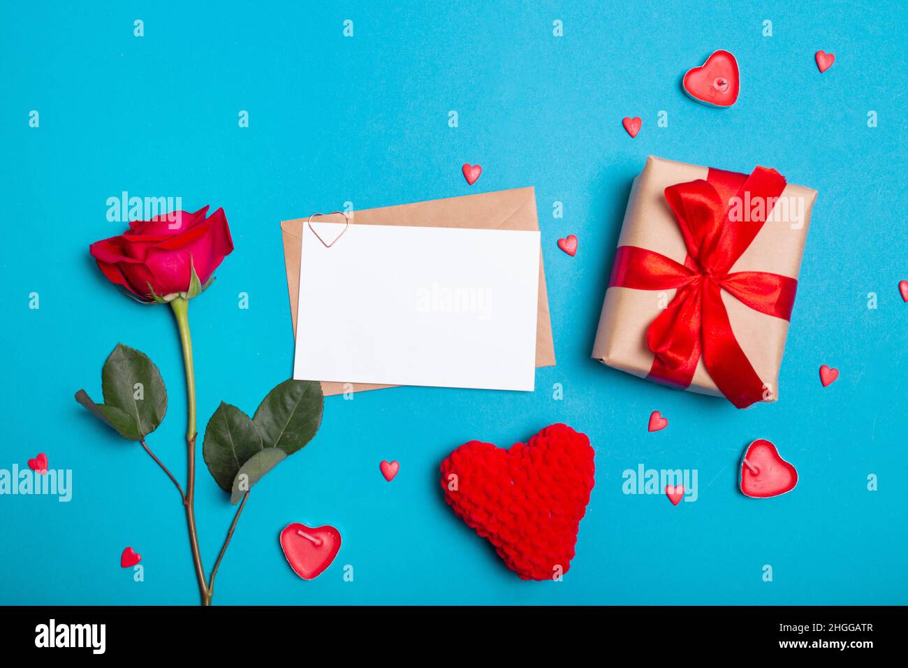 Carte de vœux de Saint-Valentin, rose rouge, cadeau, coeur sur fond bleu Banque D'Images
