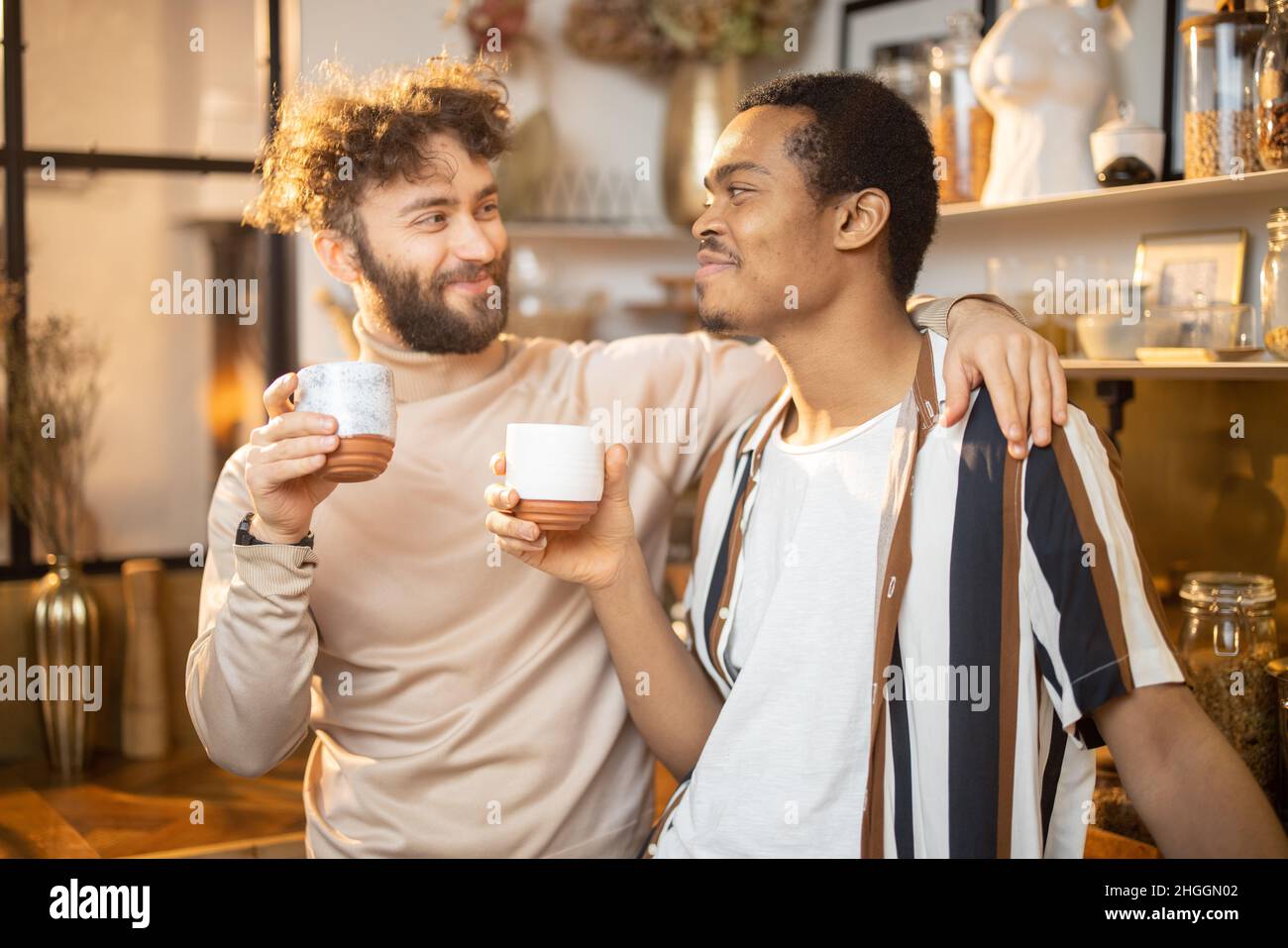 Deux hommes parlent et boivent du café dans la cuisine à la maison Banque D'Images
