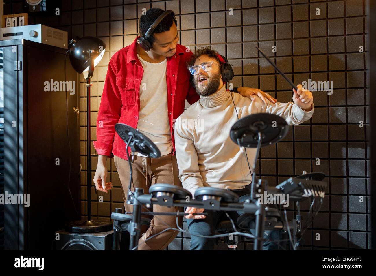 Hommes jouant des tambours électriques à la maison sstudio Banque D'Images