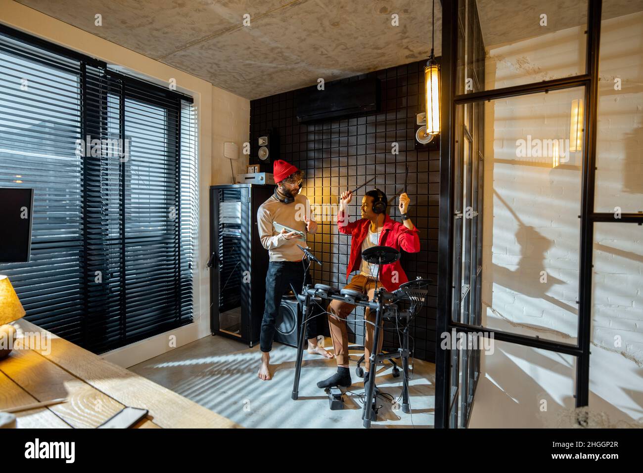 Hommes jouant des tambours électriques à la maison sstudio Banque D'Images