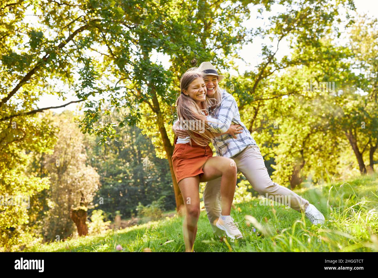 Mère et fille jouent et combattent avec enthousiasme sur un pré dans la nature en été Banque D'Images