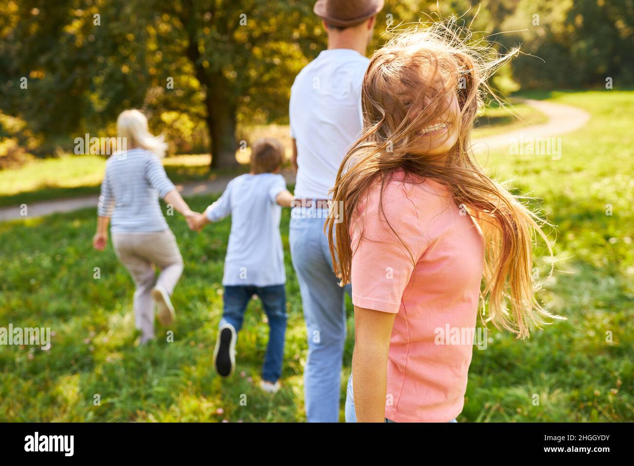 Fille avec cheveux soufflants et famille sur la nature excursion en été Banque D'Images