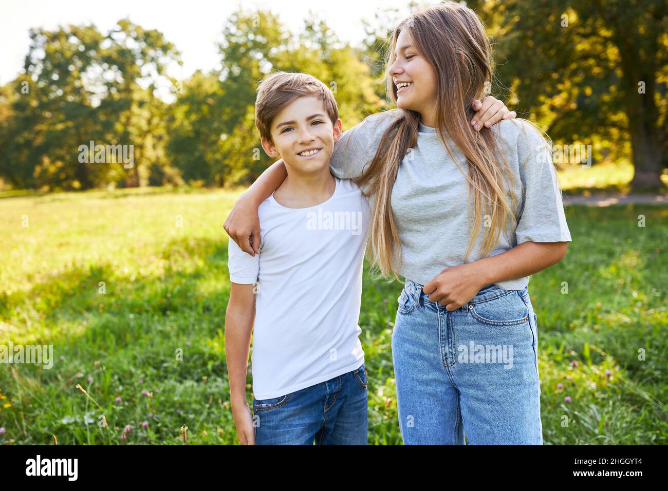 Frère et sœur qui s'embrasse avec joie dans le parc vert pendant les vacances d'été Banque D'Images