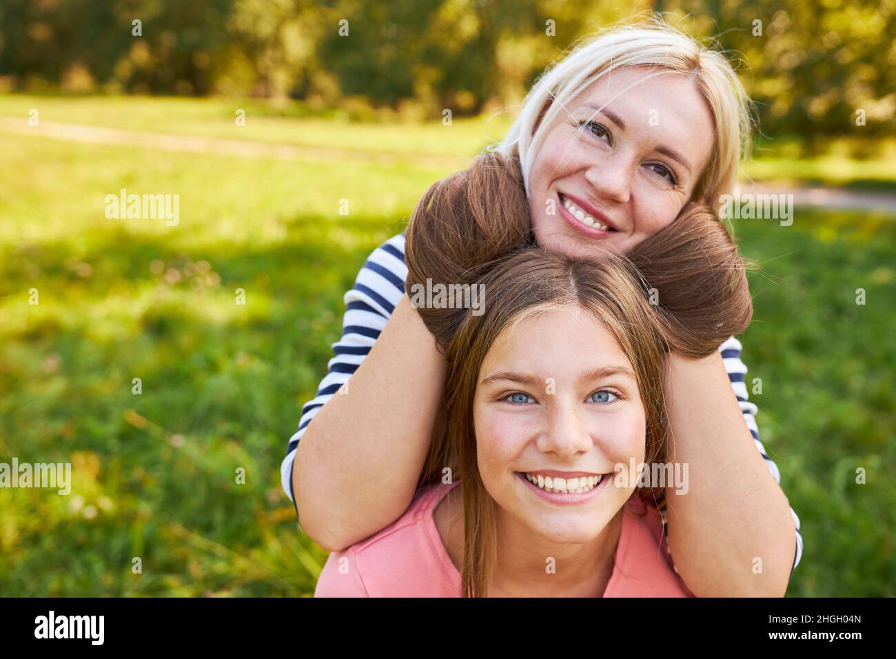 Mère se berner avec ses cheveux longs gaies de fille dans la nature dans le parc Banque D'Images