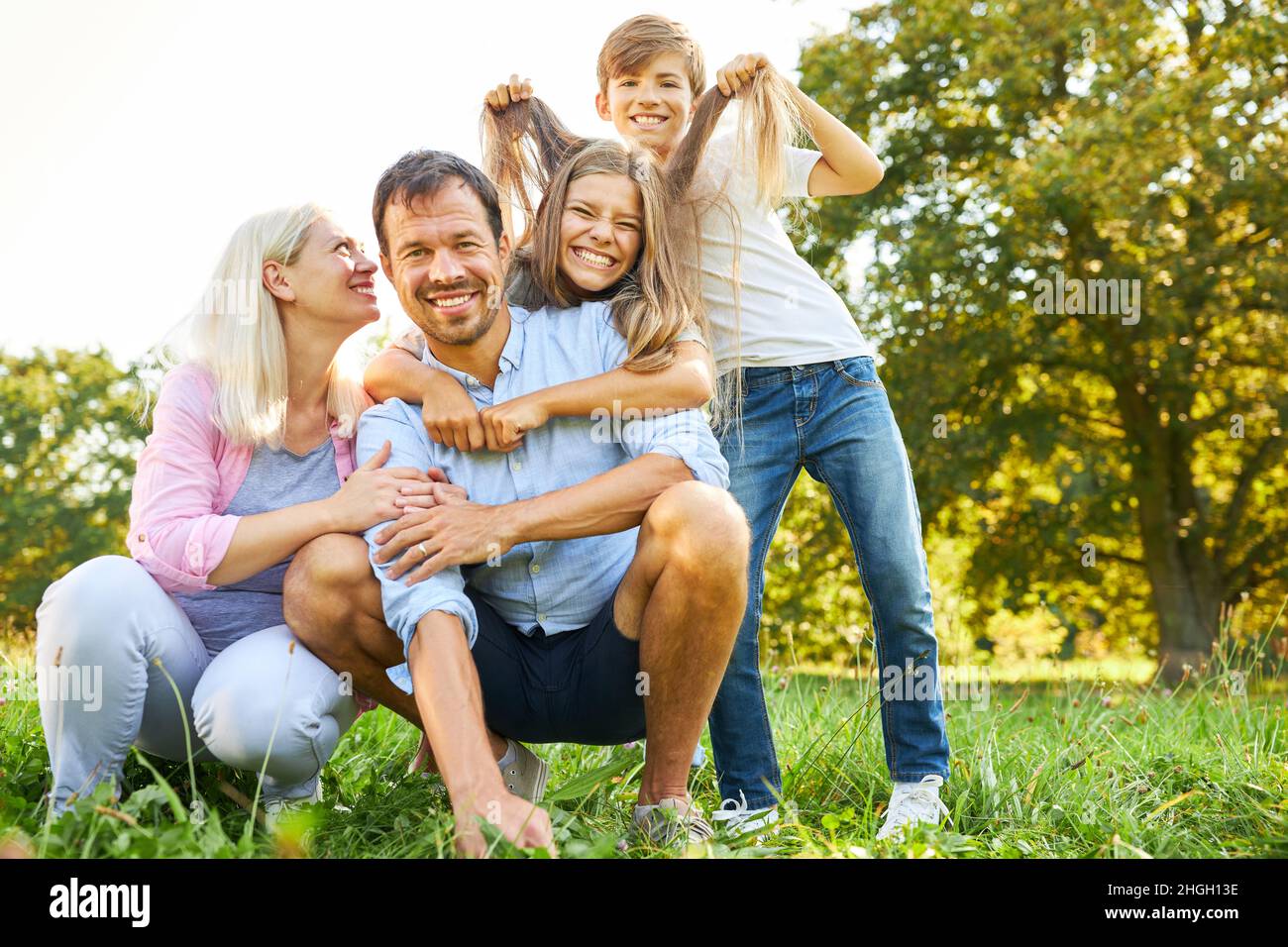 Les enfants gaies se métrompent et s'amusent avec leurs parents en été dans le parc Banque D'Images