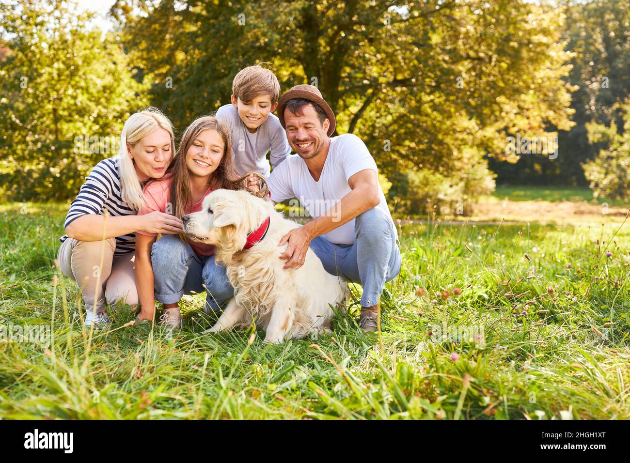 Famille heureuse avec deux enfants et chien sur un pré vert dans la nature Banque D'Images