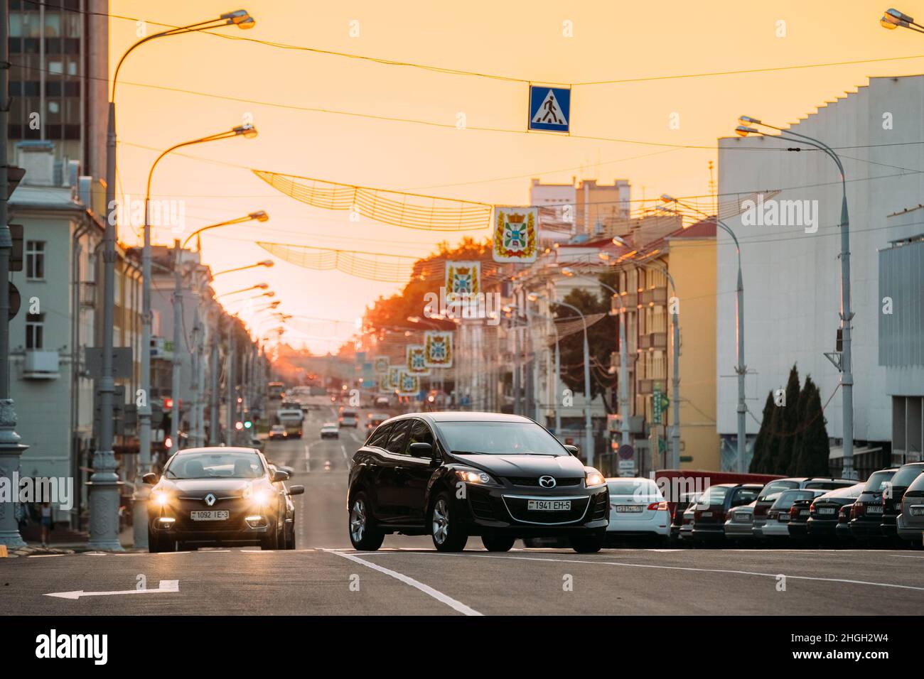 Gomel, Bélarus.Circulation sur l'avenue Lénine au coucher du soleil jaune avec le véhicule noir Mazda CX-7 Crossover Banque D'Images