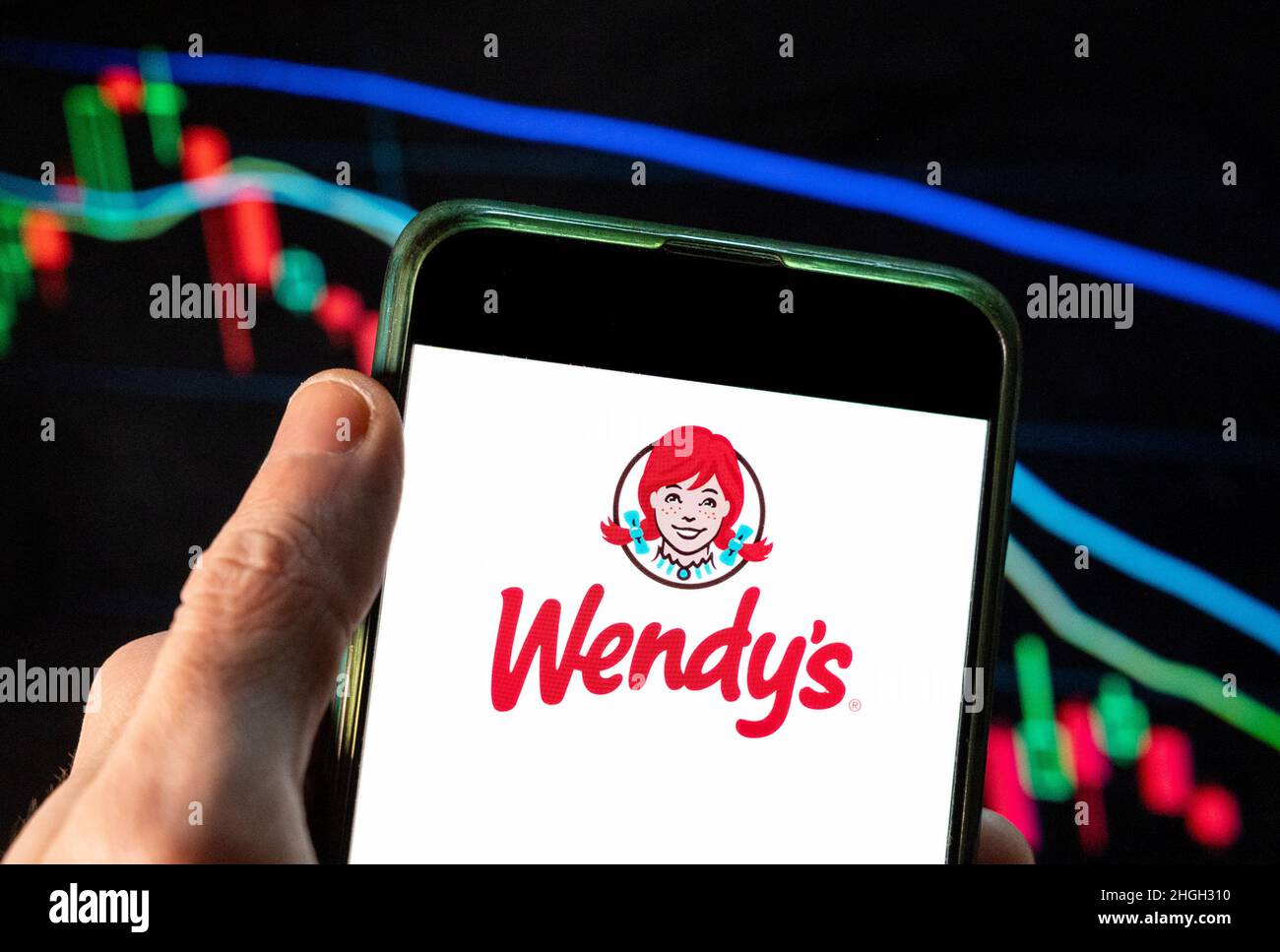 Sur cette photo, le logo de Wendy, chaîne de restauration rapide américaine, est affiché sur un smartphone avec un graphique de l'indice boursier économique en arrière-plan. Banque D'Images