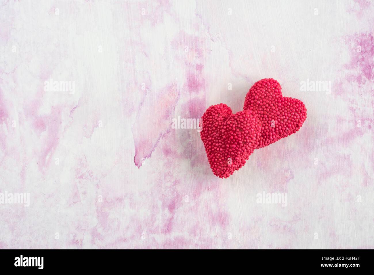 sucrée, deux bonbons en gelée en forme de coeur sur fond blanc rose ou surface avec espace de copie. concept de jour de valentines avec bonbons en forme de coeur Banque D'Images