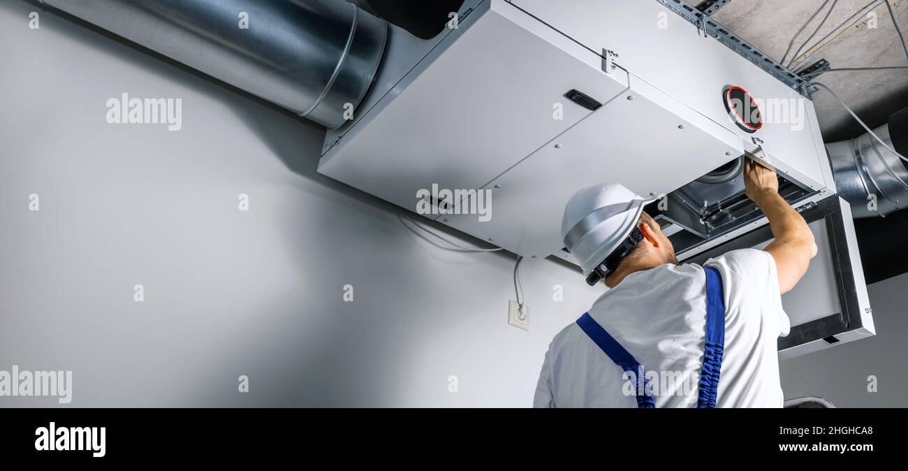 un ingénieur hvac installe un système de ventilation de récupération de chaleur pour la nouvelle maison. copier l'espace Banque D'Images