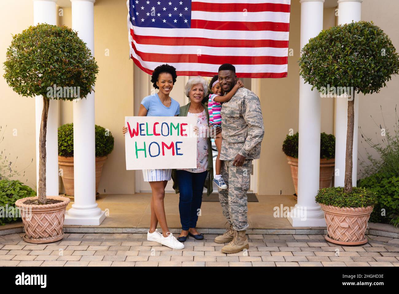 Portrait complet d'une famille de soldats afro-américains souriants célébrant le retour à l'entrée Banque D'Images