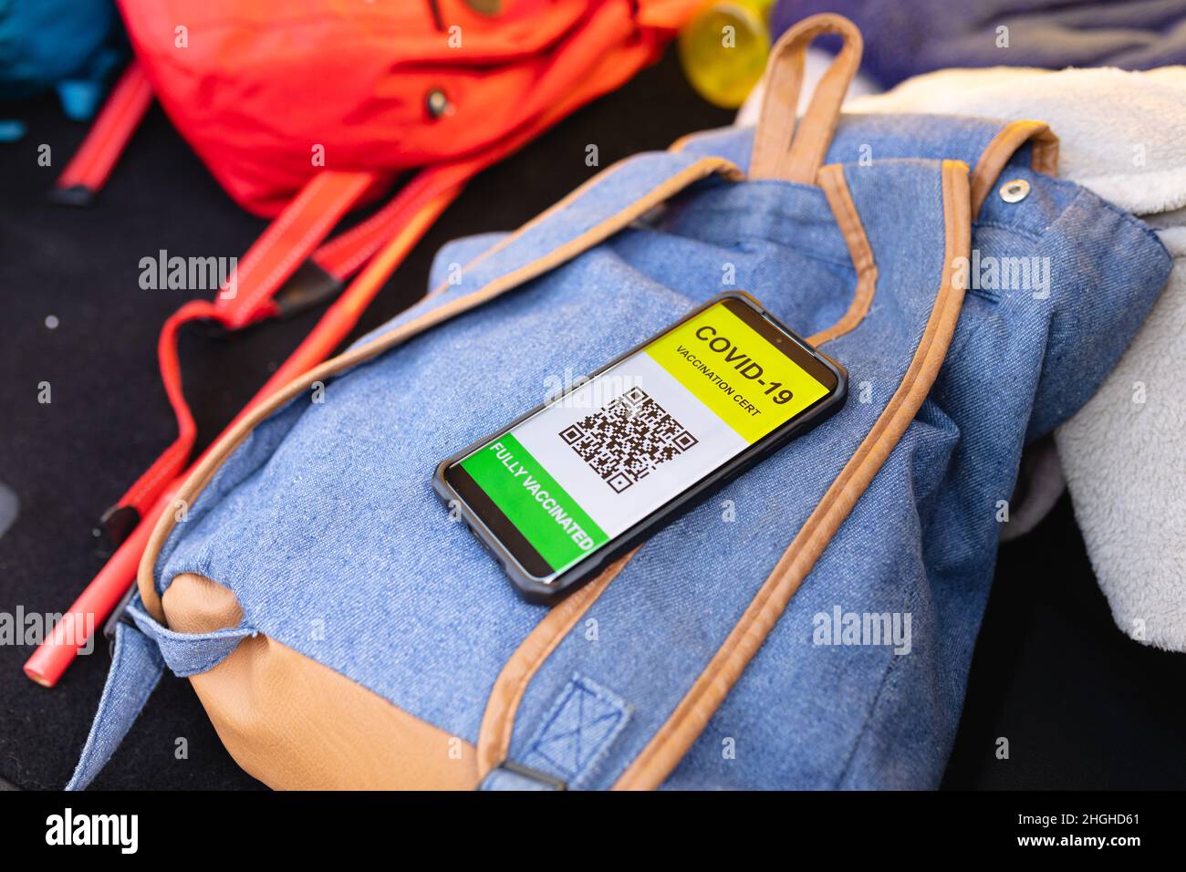 Gros plan du certificat de vaccination Covid-19 sur le smartphone sur un sac à dos Banque D'Images