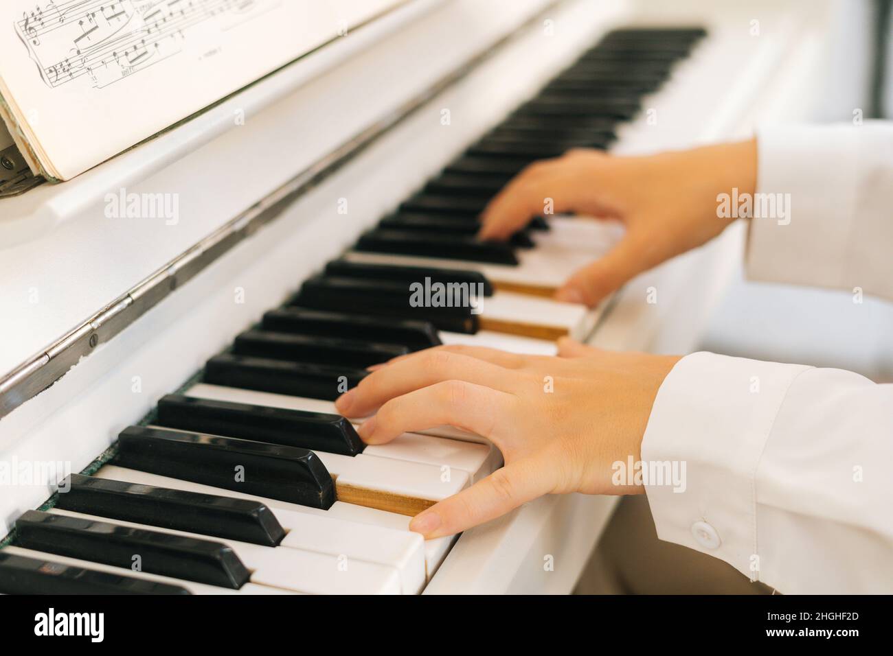 Gros plan des mains d'une musicienne non reconnaissable pianiste jouant de  la musique douce sur un piano classique blanc dans une salle de classe  légère Photo Stock - Alamy