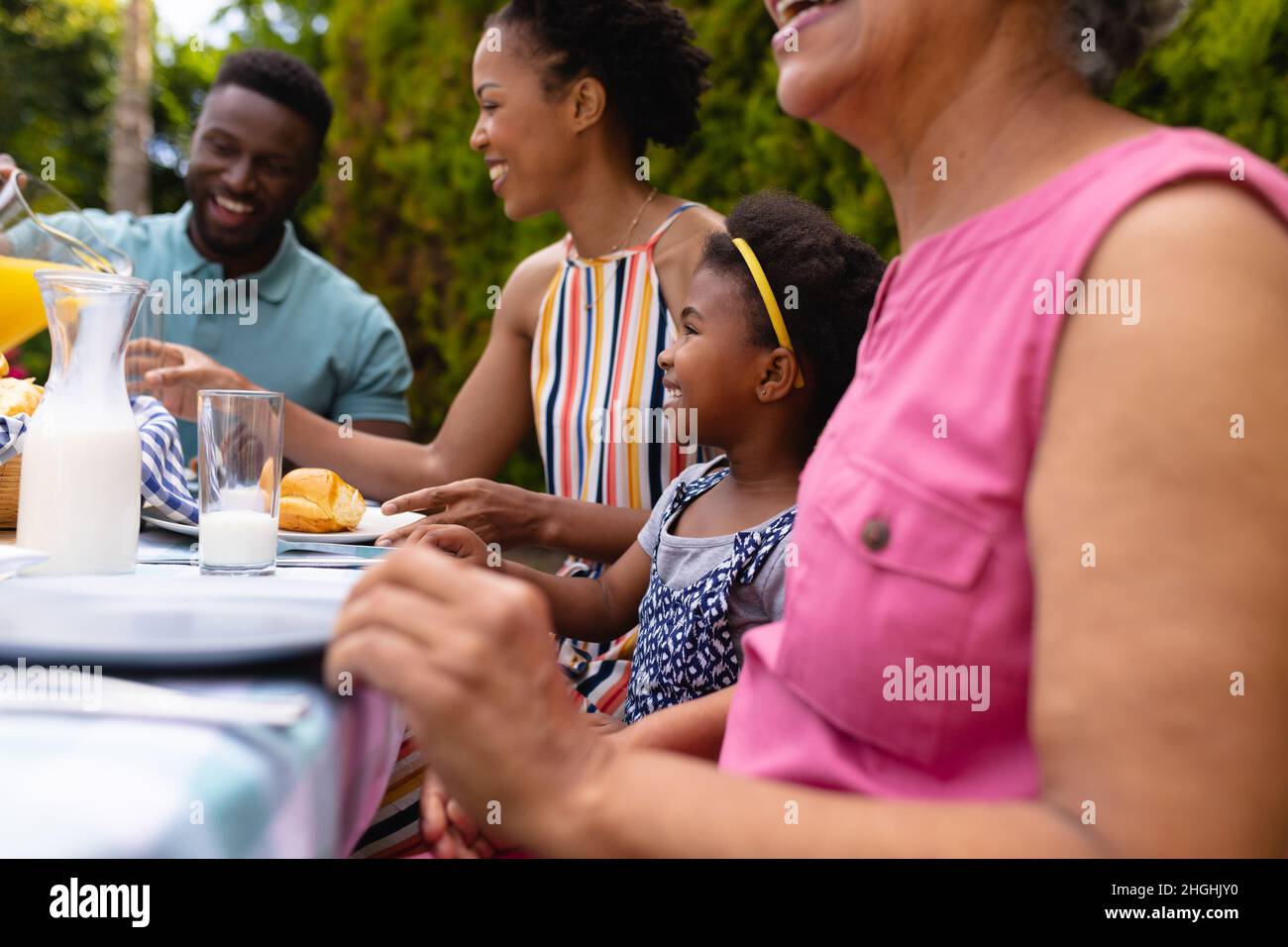 Une famille afro-américaine souriante propose un brunch dans le jardin de l'arrière-cour Banque D'Images