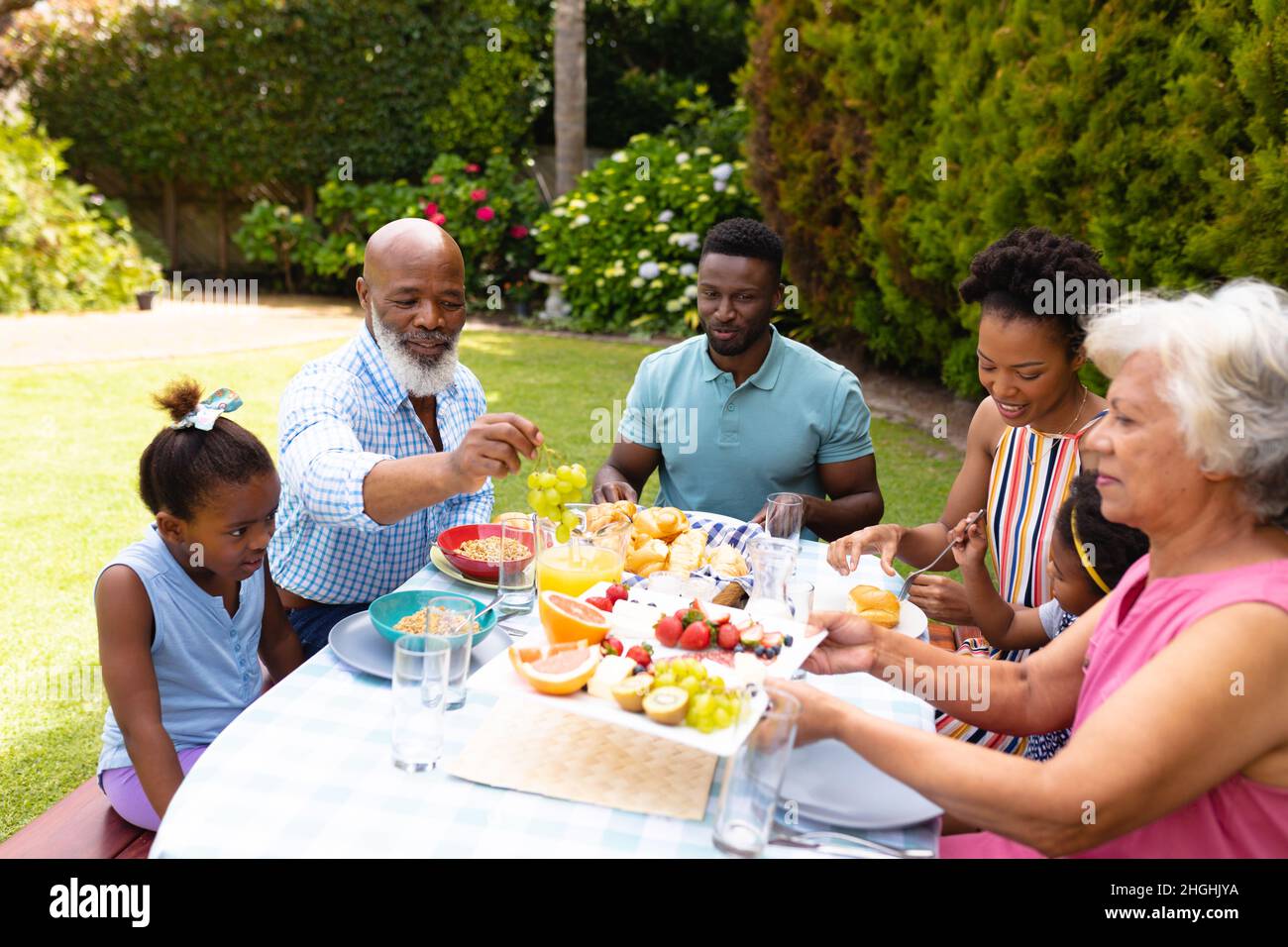 Famille afro-américaine prenant un brunch à table dans la cour Banque D'Images