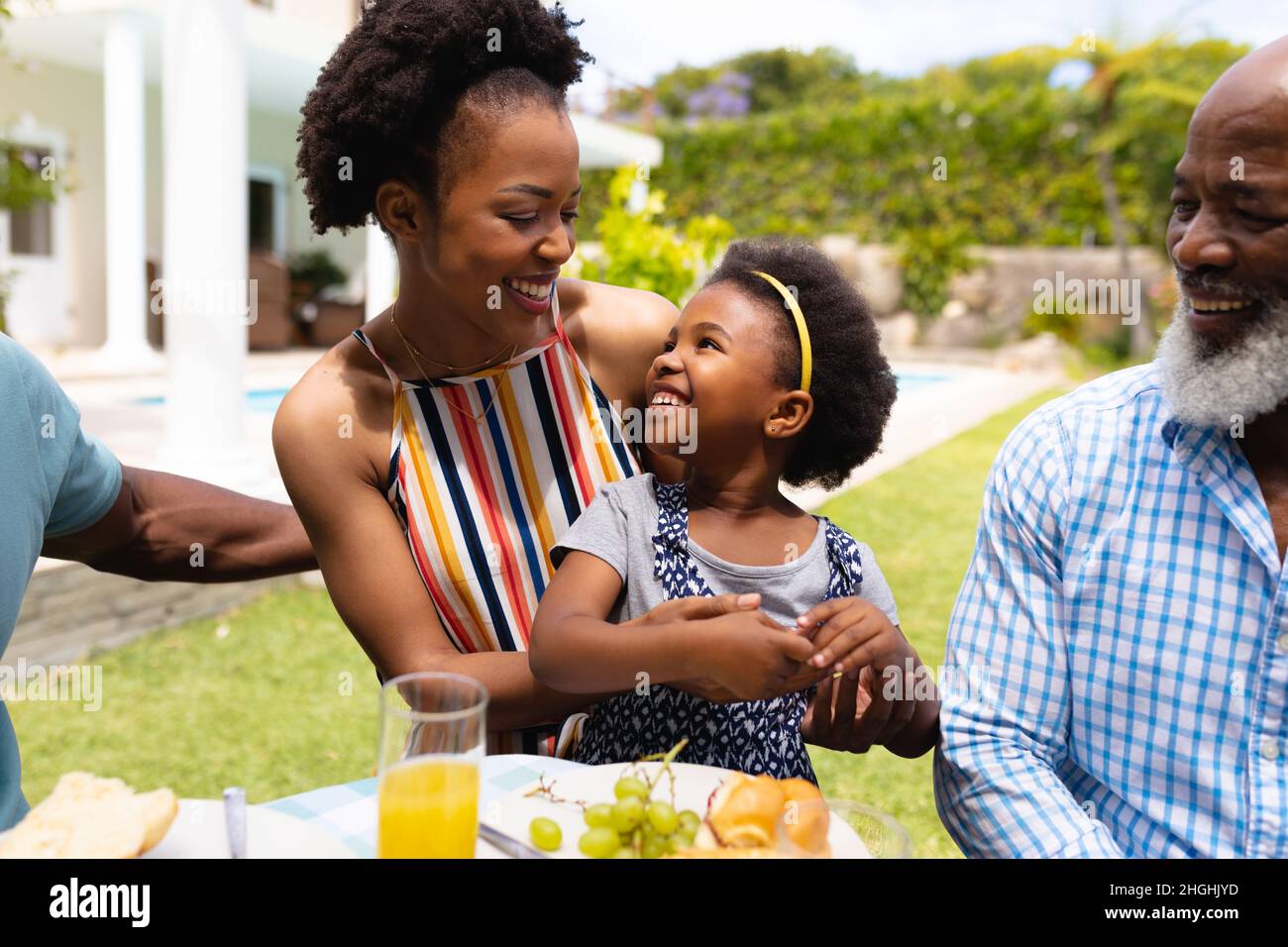 Une mère et une fille afro-américaines souriantes se regardant les unes les autres pendant le brunch Banque D'Images