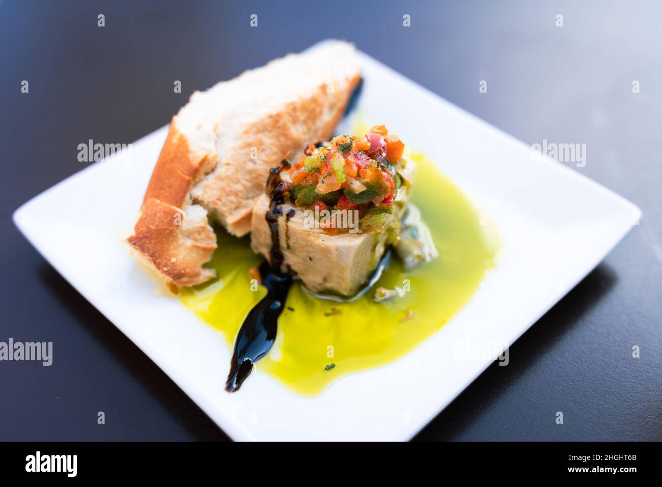 Tapa traditionnel espagnol à base de thon avec tranche de pain, poivrons hachés sur le dessus et huile d'olive.Restaurant bar snack sur l'assiette Banque D'Images