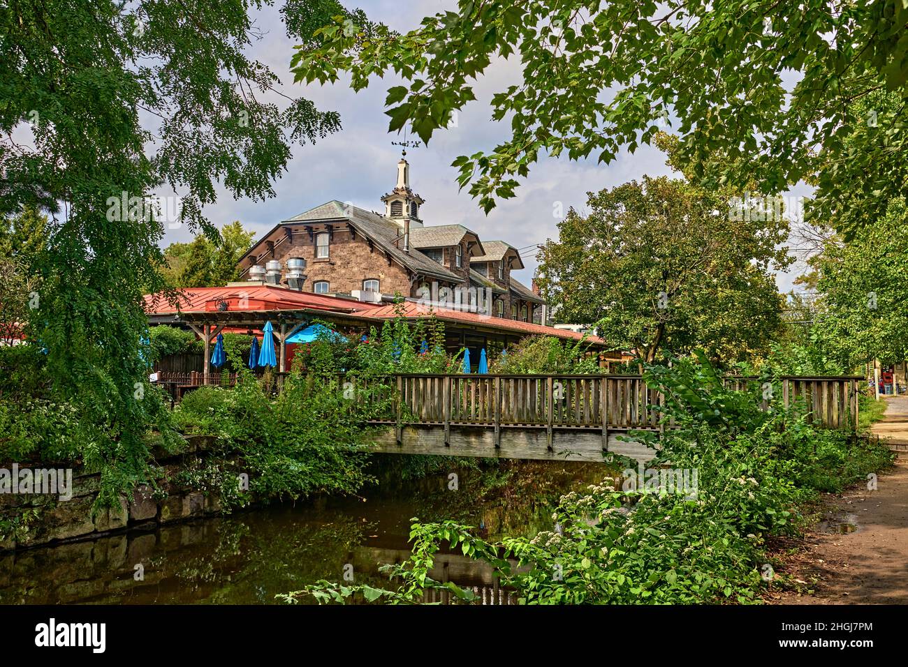 Un petit pont en bois traversant le canal du fleuve Delaware avec réflexions.by Bridge Street à Lambertville, NJ par le restaurant.Près de New Hope, Pennsylvanie. Banque D'Images