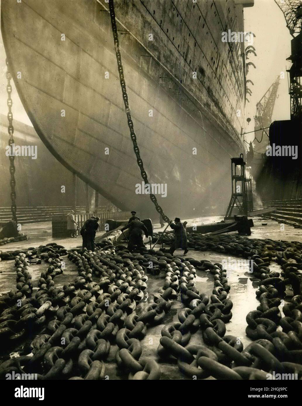 Southhampton, Angleterre, Royaume-Uni.08th janvier 1953.Des travaux sont en cours à Southampton sur la révision annuelle du plus grand paquebot au monde, QE, nommé pour le monarque britannique.Elle sera au port jusqu'en février 11, et est actuellement en cale sèche.Une armée de plus de 2000 ouvriers est engagée sur le travail.Hommes au travail sur les puissantes chaînes, sous les arcs géants du navire à Southampton aujourd'hui.Crédit : Keystone Press Agency/ZUMA Wire/Alay Live News Banque D'Images