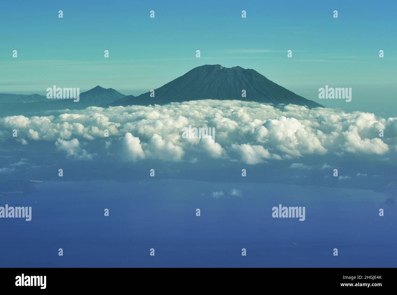 Vue aérienne du volcan du Mont Agung parmi les nuages et le littoral de Bali, Indonésie, Banque D'Images