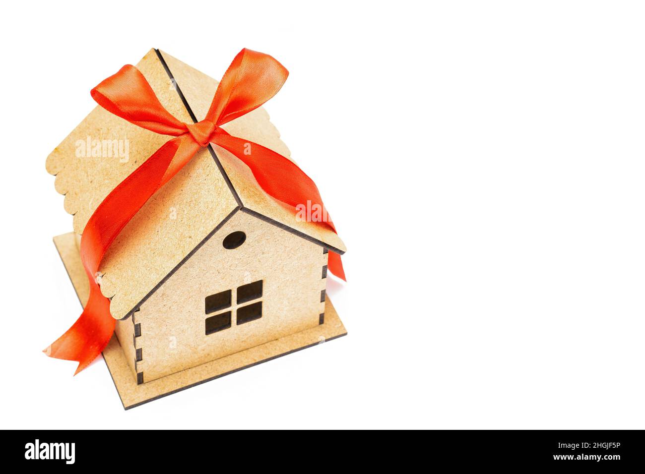 Maison de jouets avec un noeud en ruban rouge sur le dessus isolé sur fond blanc.Concept de prêt hypothécaire. Banque D'Images