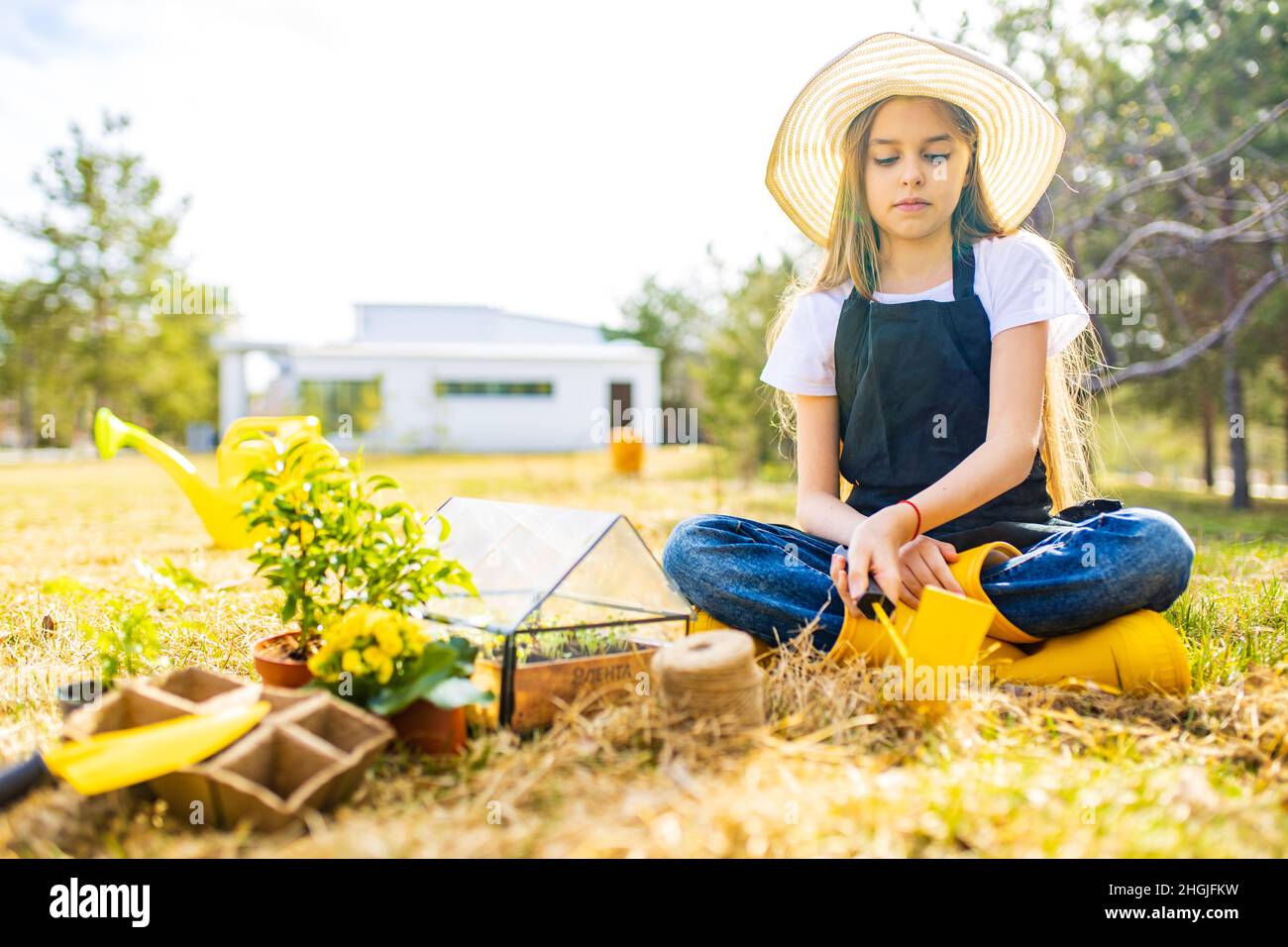 belle écolière adolescente passant du temps à l'extérieur dans le jardin porter chapeau de paille Banque D'Images