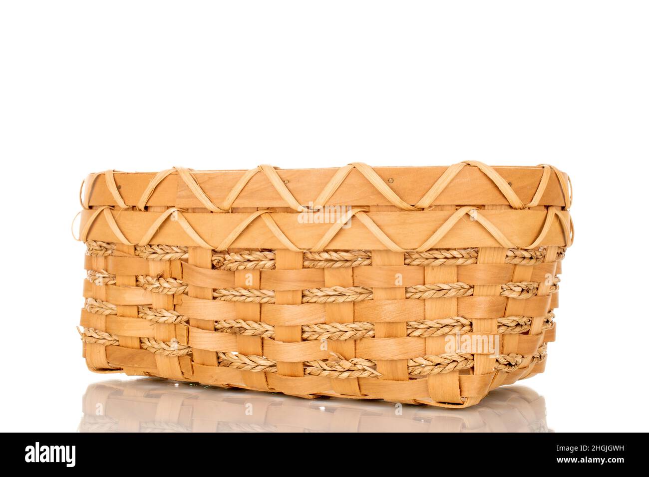 Un panier tissé à partir d'une vigne, gros plan, isolé sur blanc. Banque D'Images