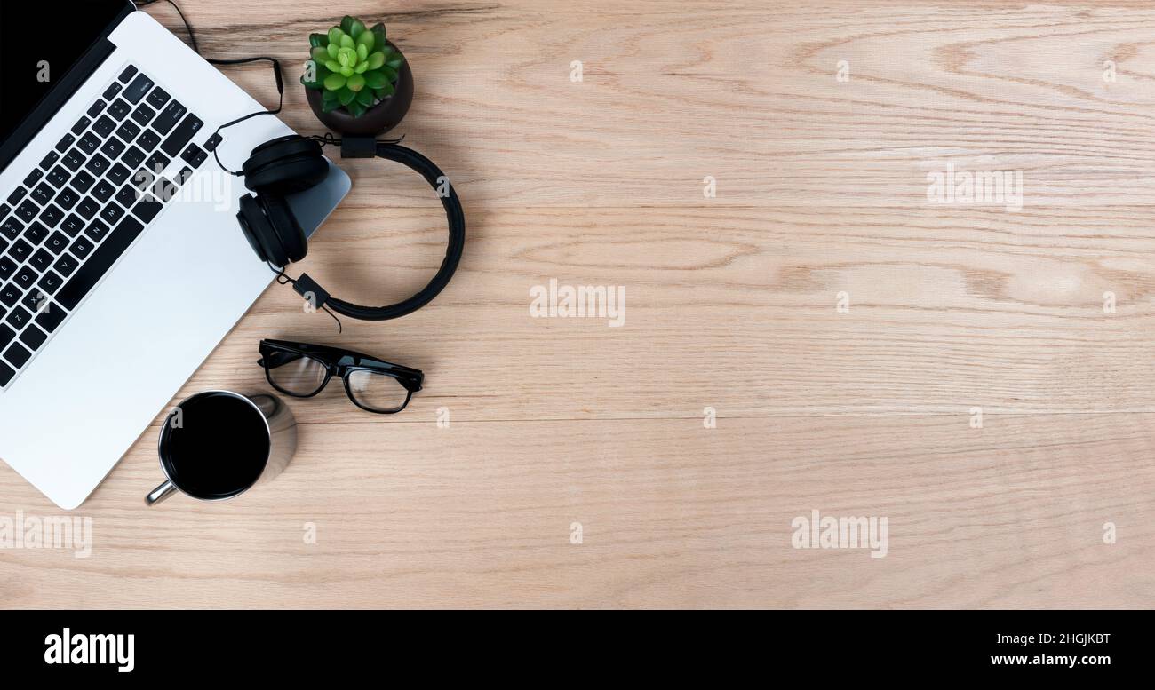 Bureau en chêne, table avec ordinateur portable, tasse de café, micro-casque et lunettes de lecture.Vue de dessus avec copie au format de mise à plat. Banque D'Images
