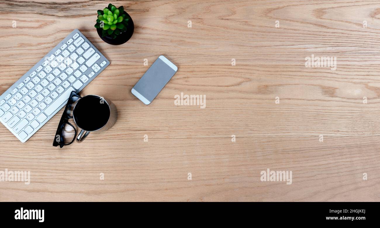 Bureau en chêne, table avec clavier d'ordinateur, tasse de café et smartphone pour les fournitures de travail.Vue de dessus avec copie au format de mise à plat. Banque D'Images