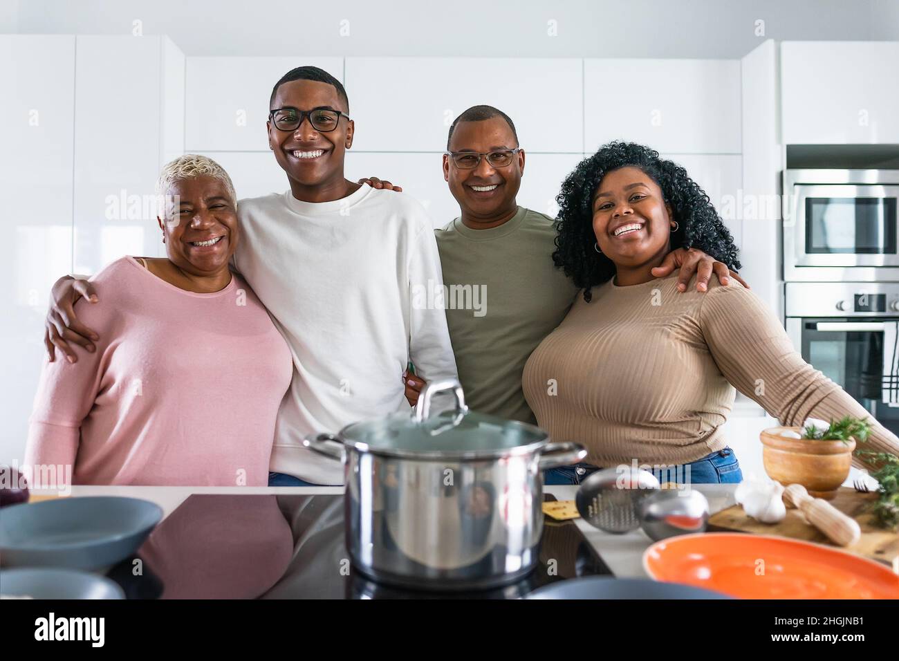 Famille hispanique heureuse ayant plaisir à cuisiner ensemble dans la cuisine moderne - concept de l'unité de la nourriture et des parents Banque D'Images