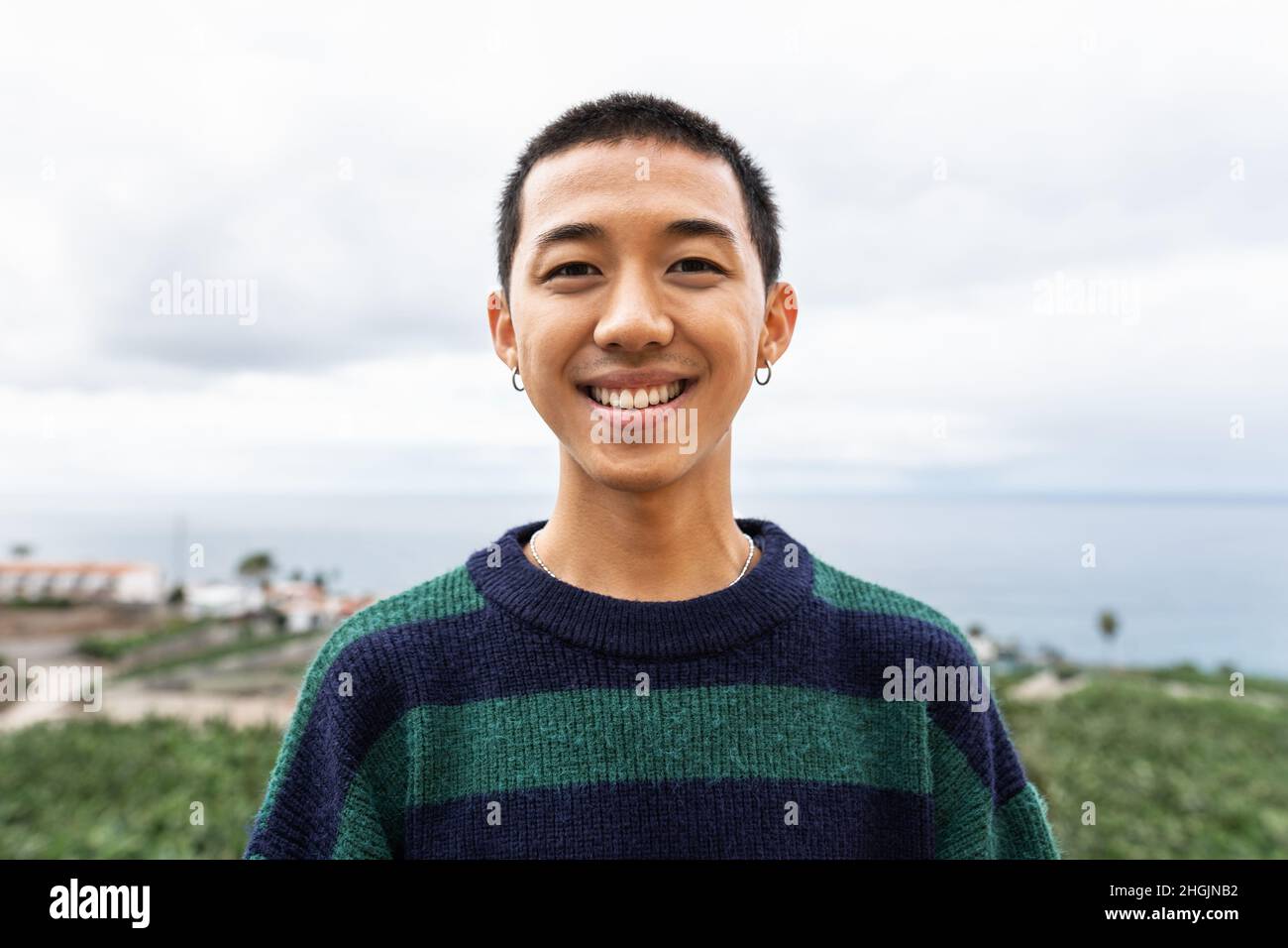 Portrait d'un jeune adolescent asiatique heureux souriant devant l'appareil photo Banque D'Images