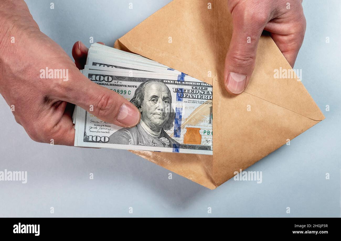 Mettre à la main de l'argent dans l'enveloppe.Corruption, salaire illégal, notion de criminalité financière. Banque D'Images