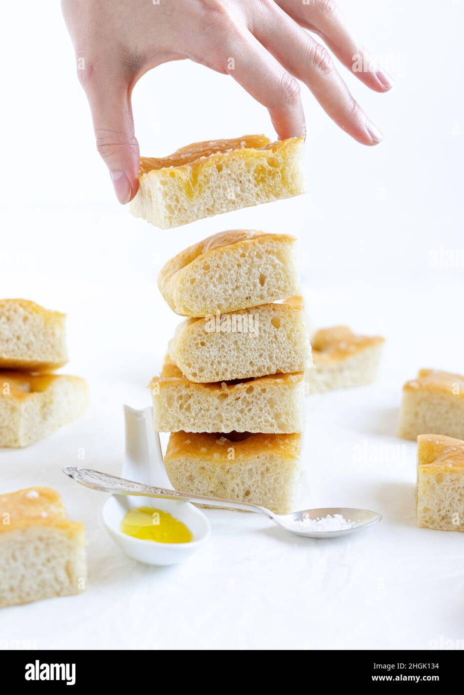 Pain italien focaccia coupé en tranches, une tranche tenue à la main Banque D'Images