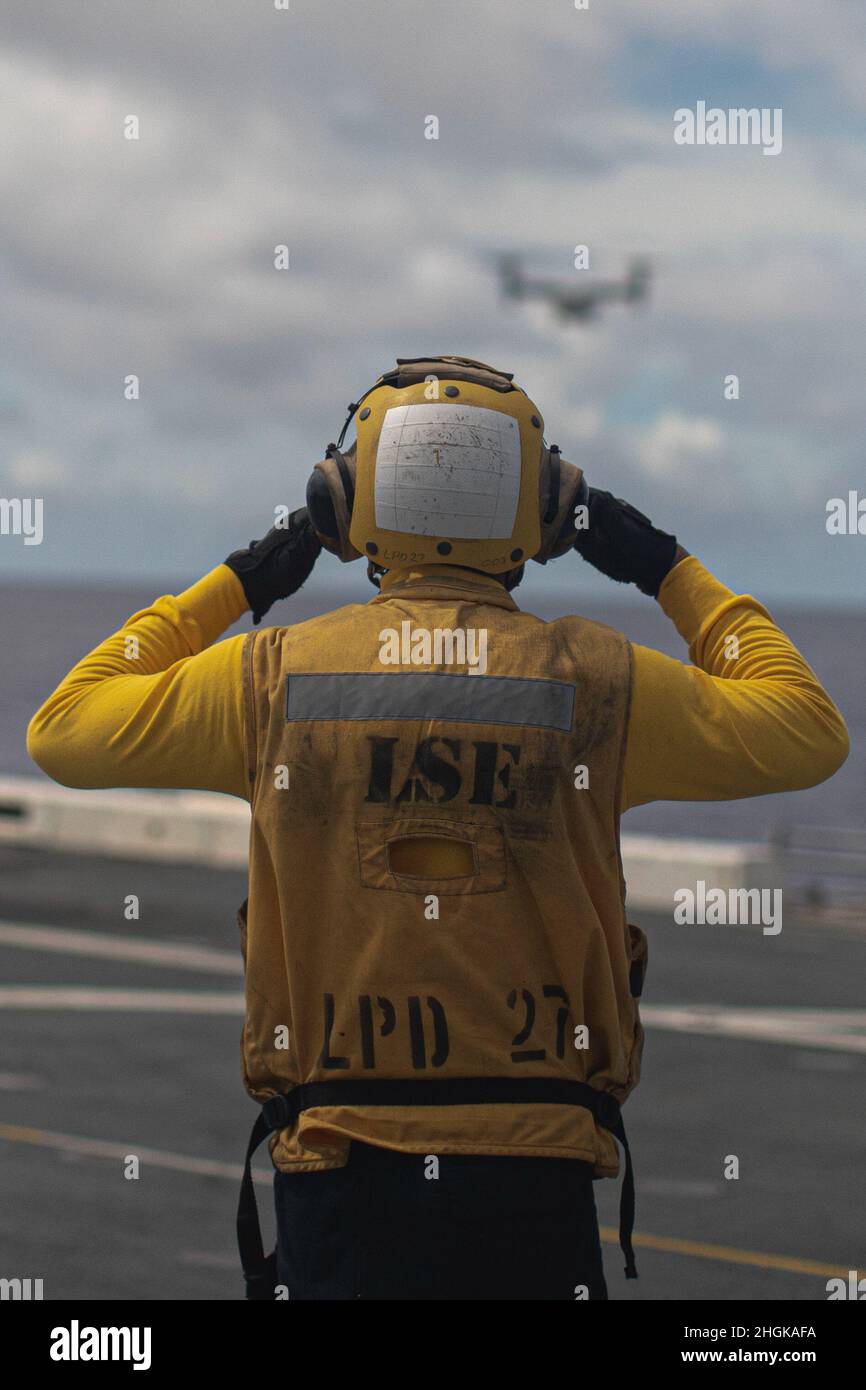 Un marin américain affecté au quai de transport amphibie USS Portland (LPD 27), guide un Osprey MV-22B avec le Marine Medium Tiltrotor Squadron (VMM) 165 (rein.), 11th MEU, alors qu'il se prépare à atterrir à bord du pont de vol, le 31 août 2021.Portland, qui fait partie du USS Essex Amphiobie Ready Group, ainsi que du MEU 11th, opère dans la zone de responsabilité de la flotte américaine 7th afin d'améliorer l'interopérabilité avec les alliés et les partenaires et de servir de force de réaction prête à l'emploi pour défendre la paix et la stabilité dans la région Indo-Pacifique. Banque D'Images