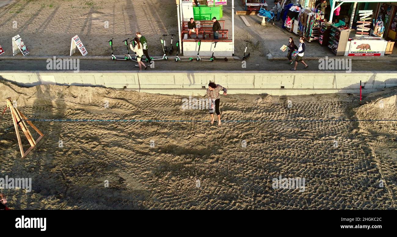 Vue aérienne au-dessus de l'équilibre mâle de la corde et de faire des acrobaties, à côté de la promenade sur Pacific Beach à San Diego, Californie, États-Unis Banque D'Images