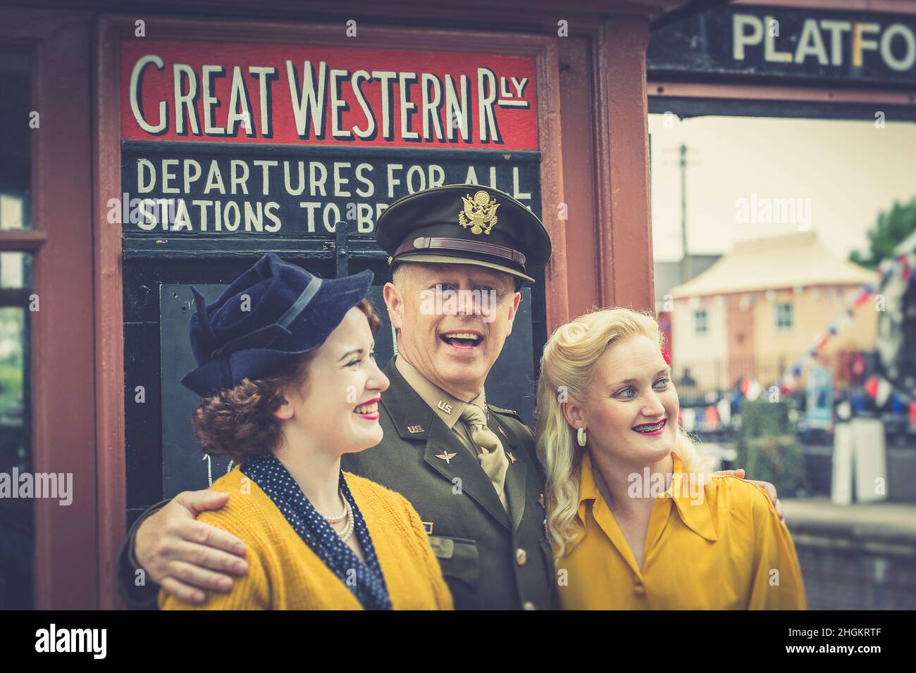 Événement 1940s à Severn Valley Railway, Kidderminster Station, Royaume-Uni.L'homme en uniforme se tient dans le foyer avec deux femmes en costume de guerre. Banque D'Images