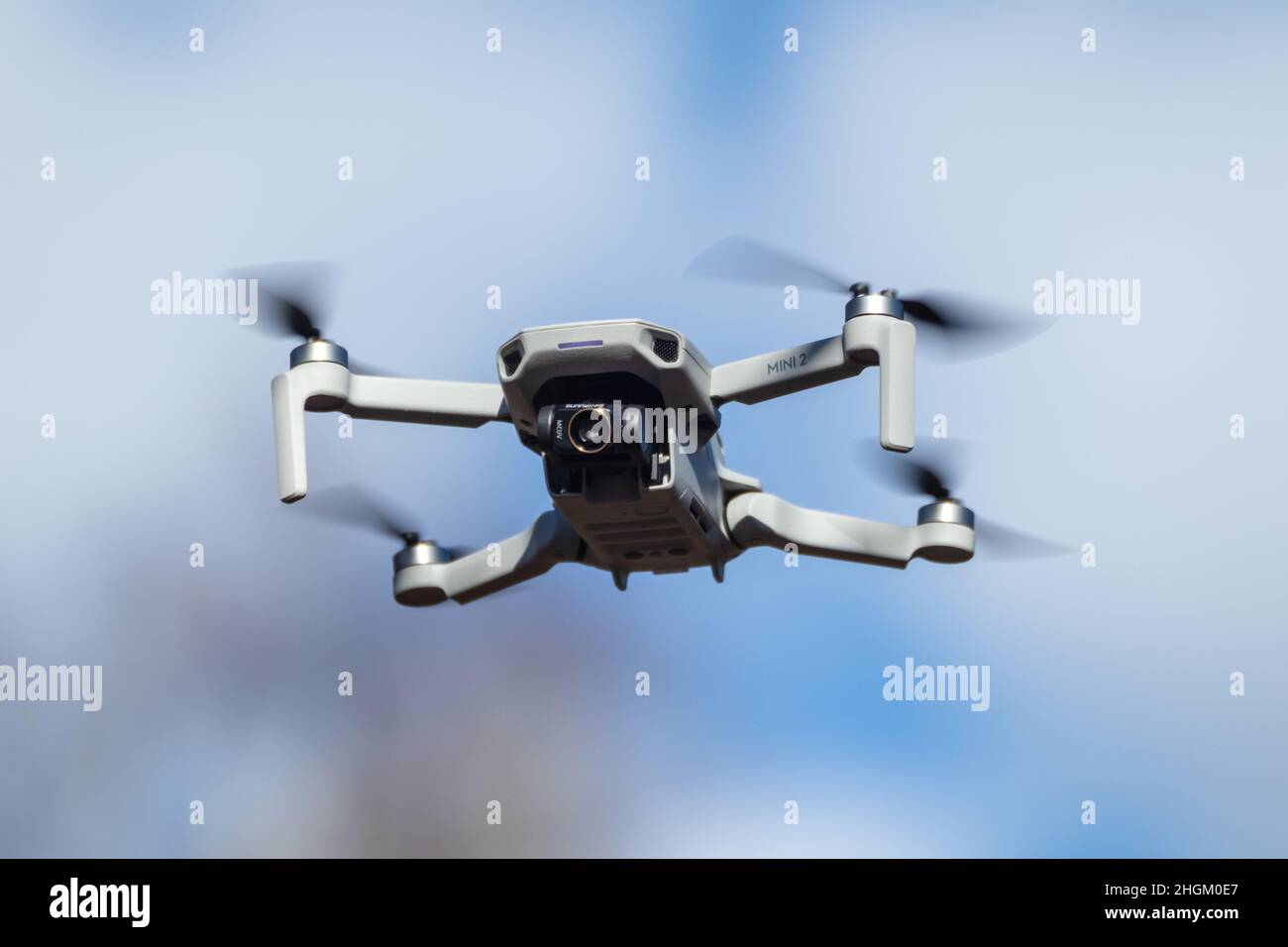 Kharkiv, Ukraine - 6 mars 2021: DJI Mavic Mini 2 drone avec filtre d'objectif d'appareil photo, vol dans le jour bleu ensoleillé.Nouveau périphérique quadcopter survolant blurr Banque D'Images