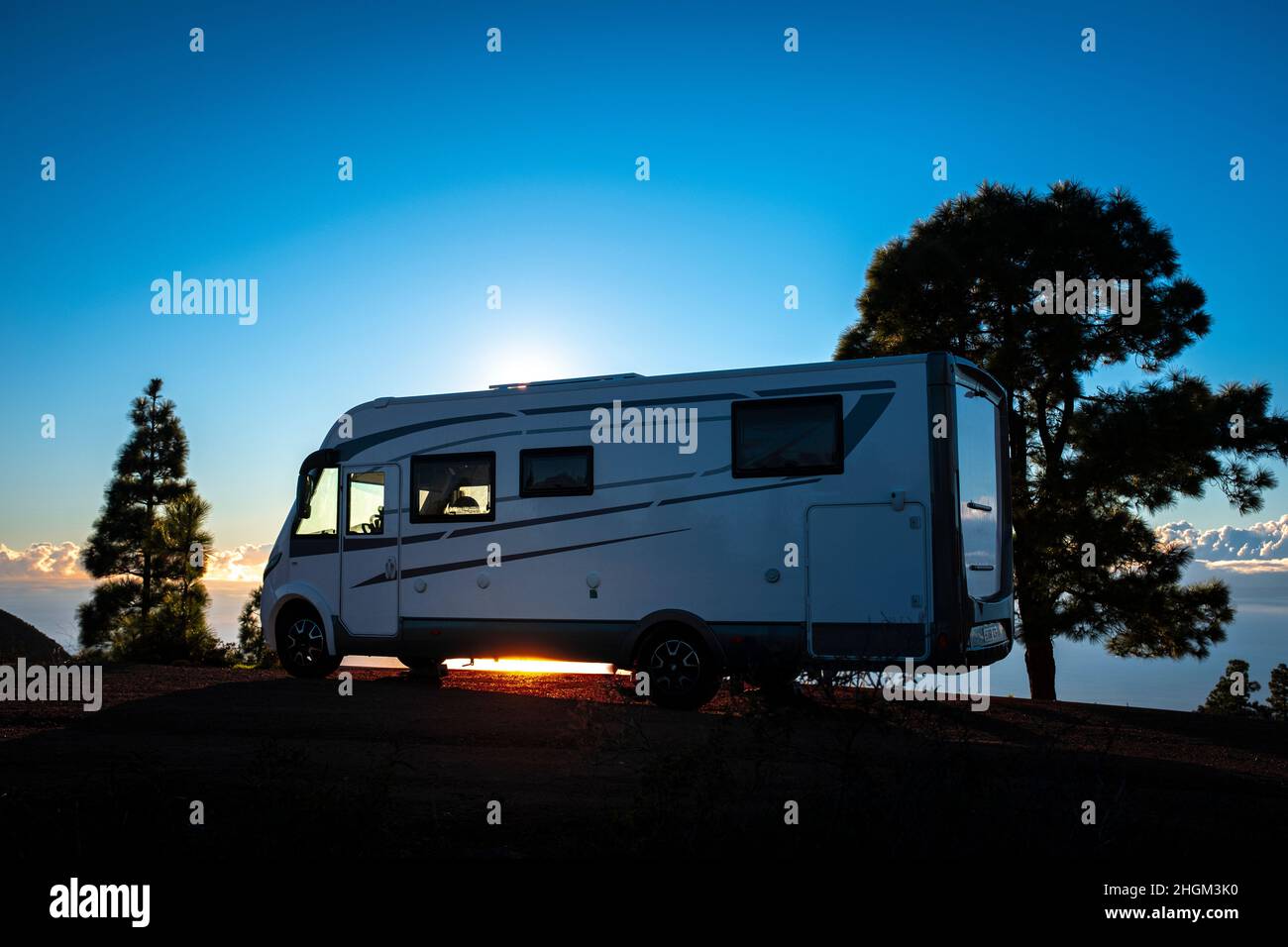 Camionnette de camping garée contre la lumière du coucher du soleil et les arbres.Concept de mode de vie alternatif vanvie et voyage wanderlust.Vacances d'été avec camping Banque D'Images