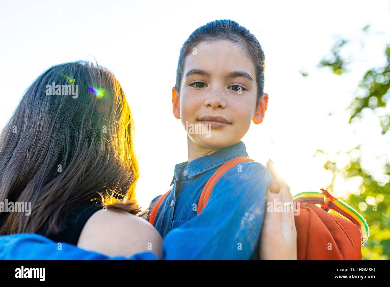 Jeune fille indienne souriante portant un sac à dos d'école et un t-shirt bleu dans le parc Banque D'Images