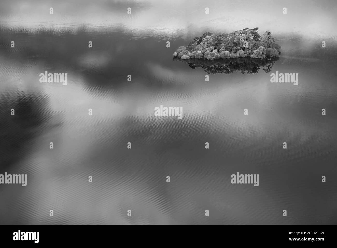 Noir et blanc Paysage abstrait image d'automne de vue des îles de Derwentwater avec des reflets de ciel les isolant avec des couleurs d'automne vibrantes Banque D'Images