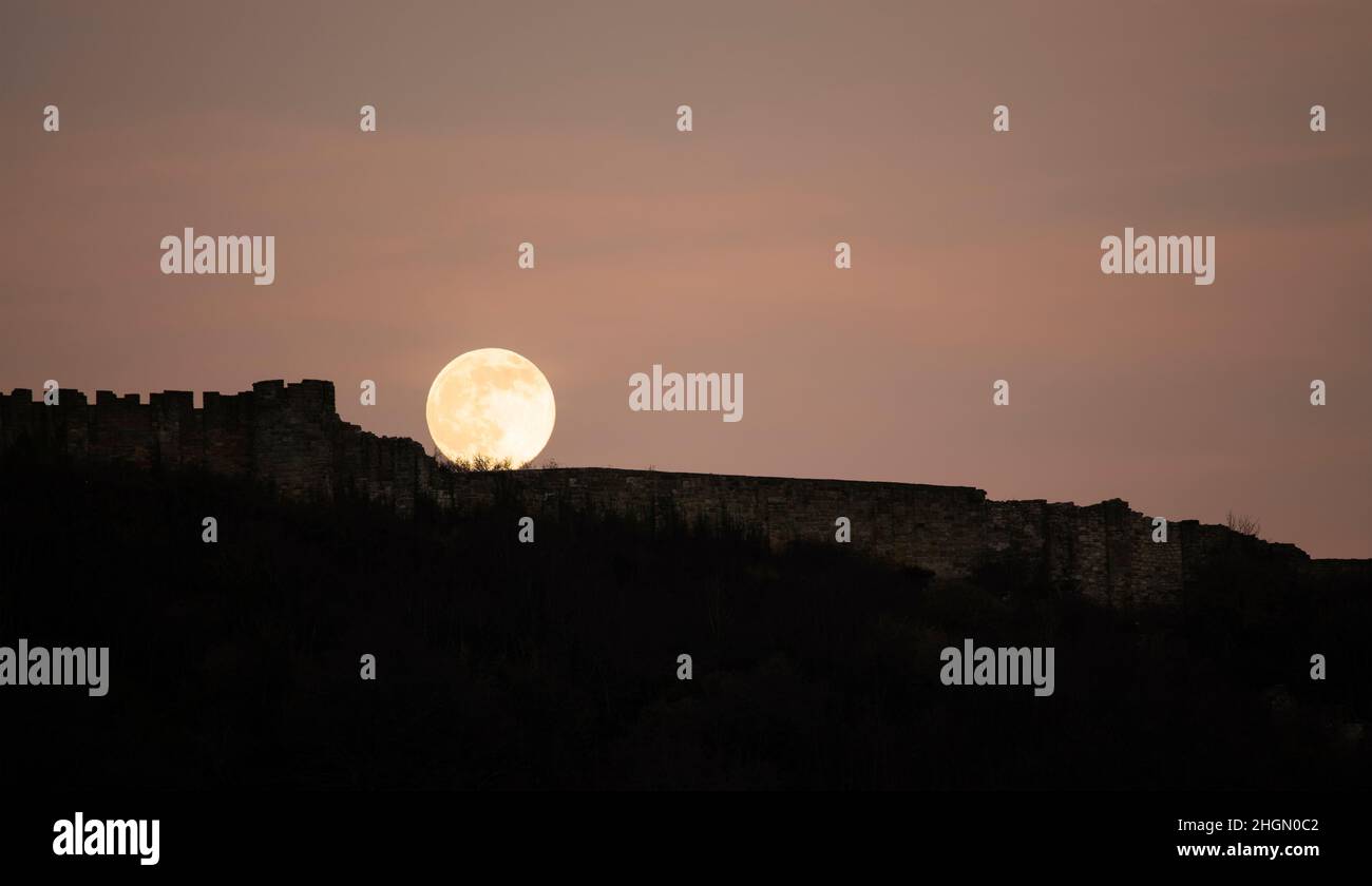 La pleine lune de janvier, connue sous le nom de Wolf Moon, s'élève au-dessus du mur-rideau du château de Scarborough.Le cycle lunaire régulier a été étudié par l'humanité Banque D'Images