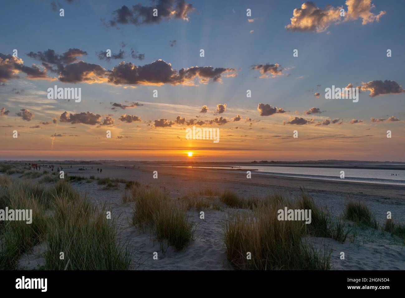 Des rayons crépusculaires éclatants rayent le ciel du coucher du soleil à Burrow Beach, dans une chaude soirée de juin. Banque D'Images