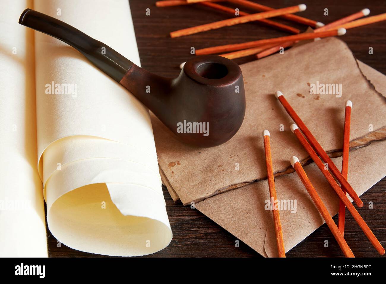 Bureau rétro dans la cabine du navire avec un tuyau de fumée, allumettes, et lettre brûlée.Atmosphère vintage encore vie Banque D'Images
