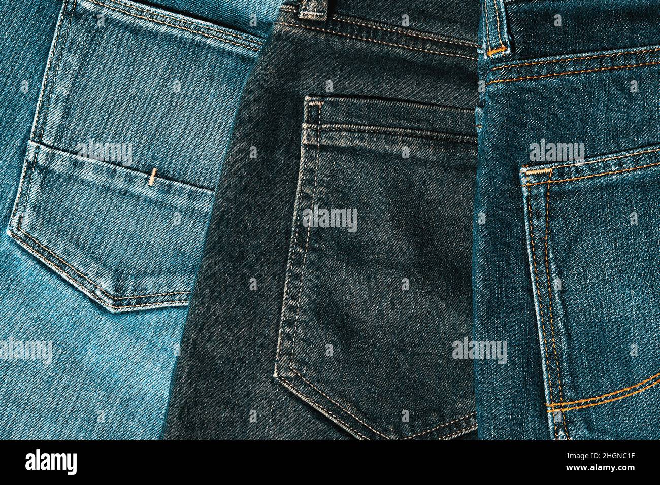 Un tas de jeans indigo a tourné les poches arrière sur le bureau de la boutique.Vêtements et fonds textiles.Image aux tons chauds Banque D'Images