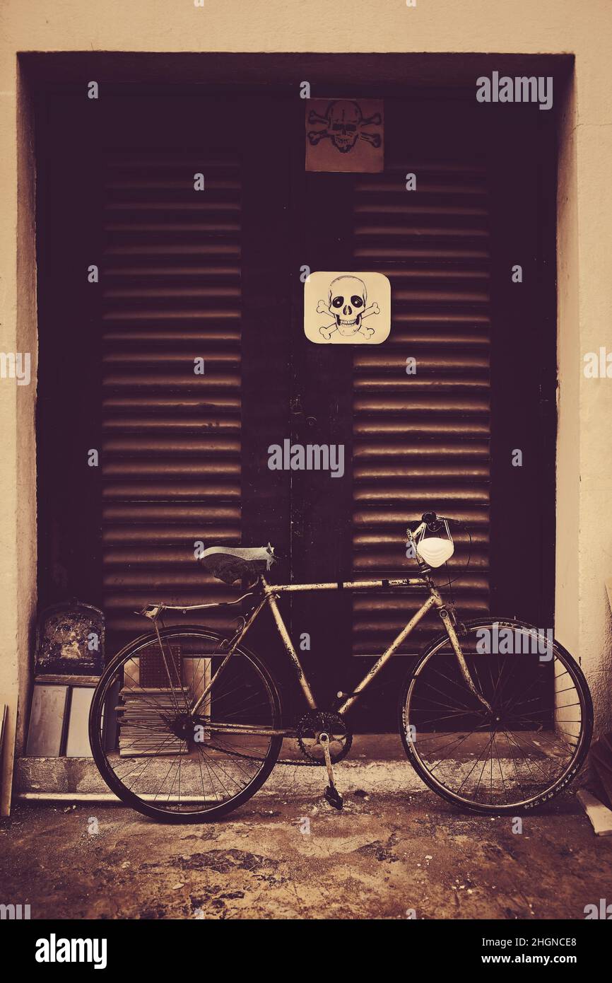 Étiquette d'avertissement sur la porte d'un centre électrique et vélo stationné à côté. Banque D'Images